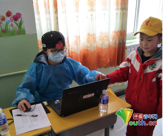 志愿者马小娇为学生进行体检。河南牧业经济学院团委 供图