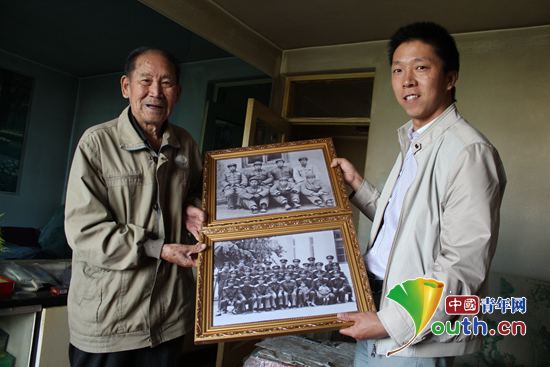 2015年9月，祁兴飞（右）为93岁的抗战老兵赠送返拍老照片。河南牧业经济学院团委 供图