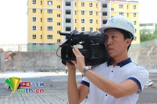 2014年7月，祁兴飞在建筑施工一线进行采访。河南牧业经济学院团委 供图